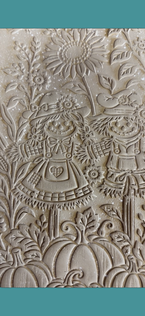 Sharon Hoppe Designs textured rolling pin featuring a detailed scarecrow, sunflower, and pumpkin fall harvest pattern.